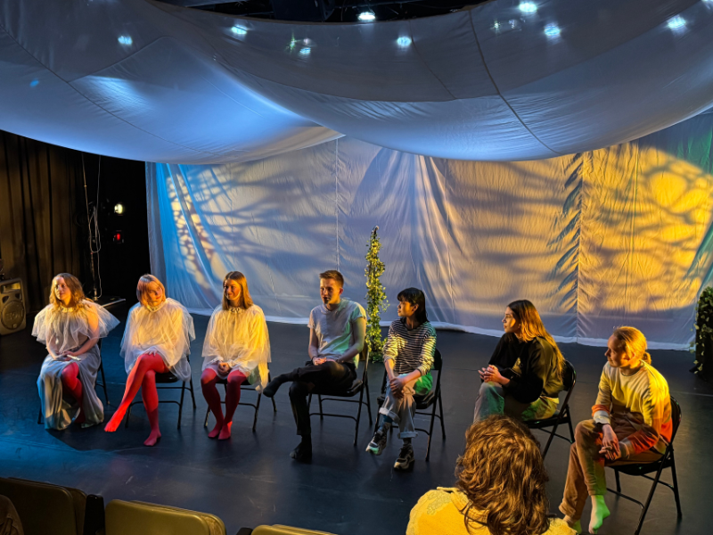 A group of people sit on a stage.